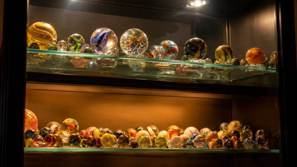 Two lit shelves of the cabinet viewed at an angle, one warm amber and one cool, showing the color light effect